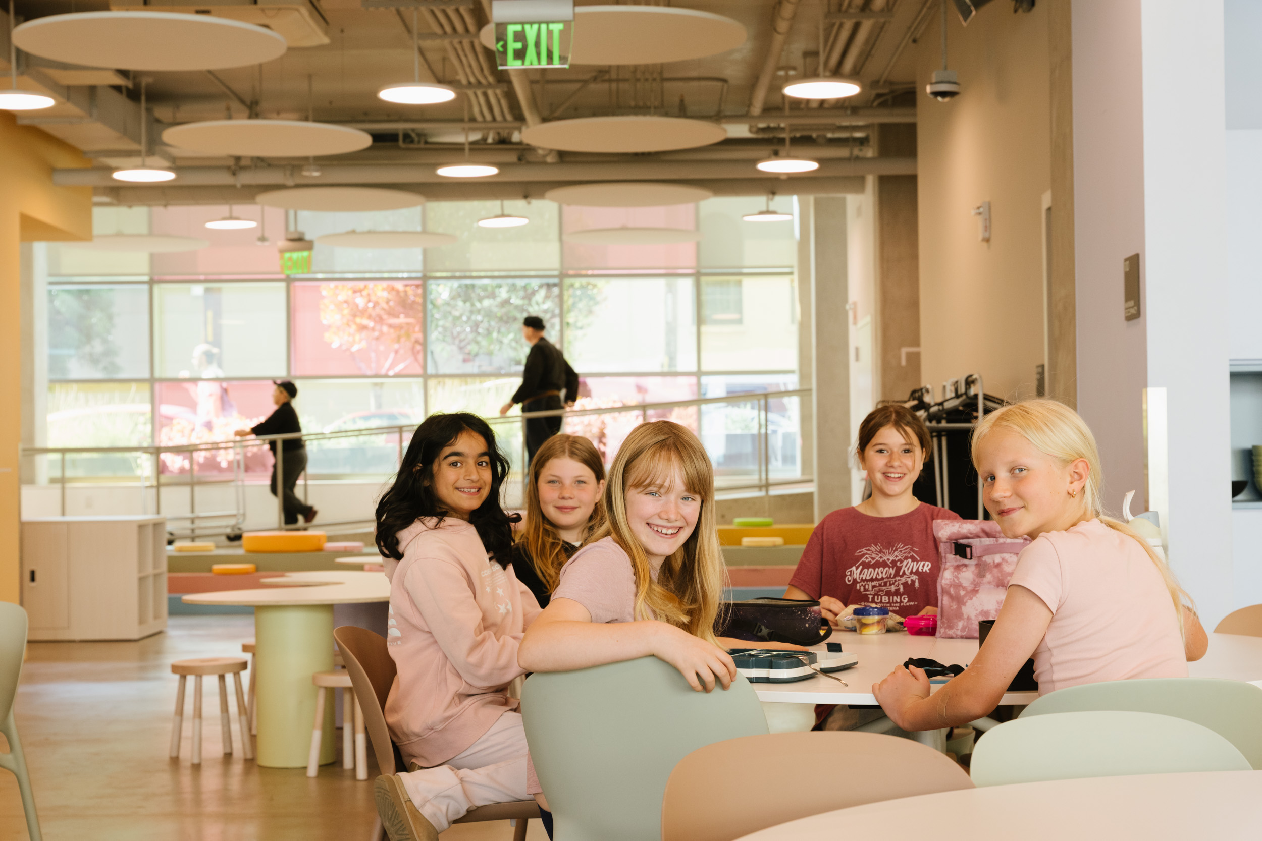 Students gathered around low tables in a bright open commons
