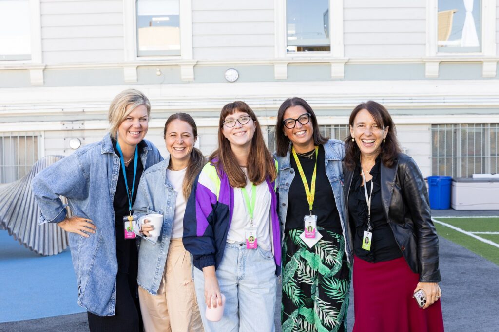 Five La Scuola staff members standing together on the rooftop play court